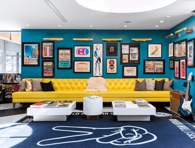 Lobby with yellow couch and lots of framed music posters at The Verb Hotel