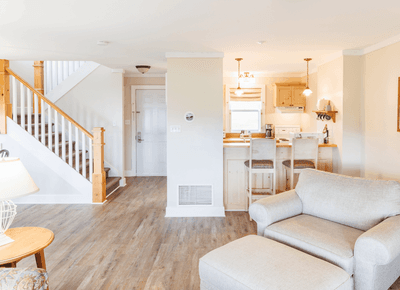 Multi-level cottage interior showing a living room with staircase, and kitchen area at Rodd Crowbush Golf & Beach Resort