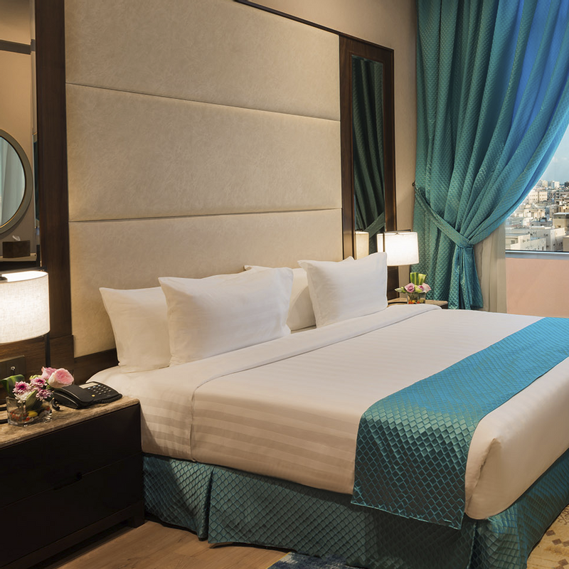Junior Suite interior with a city view at Naviti By Warwick Dammam