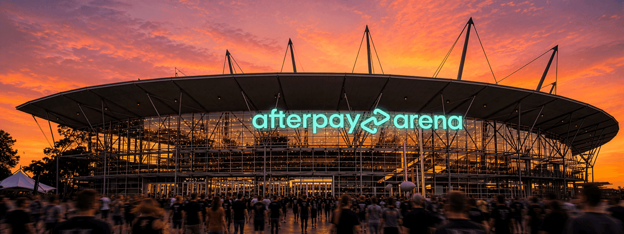 Modern arena with illuminated Afterpay Arena signage at sunset with crowds gathering outside the venue entrance.