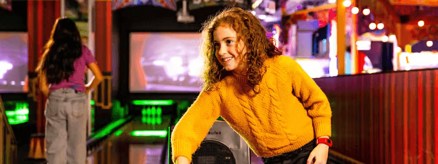 Smiling girl choosing a bowling ball at Archie Brothers Cirque Electriq near Novotel Sydney International Airport