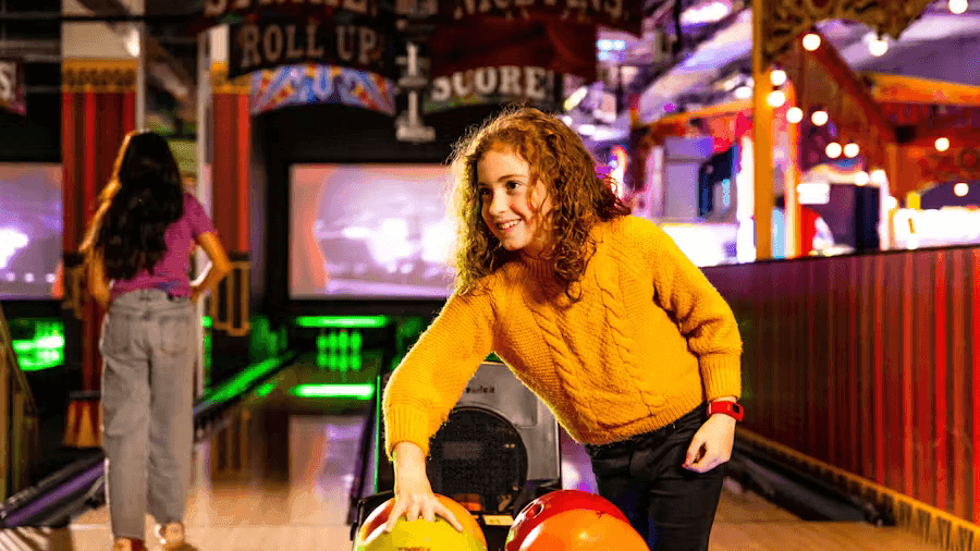 Smiling girl choosing a bowling ball at Archie Brothers Cirque Electriq near Novotel Sydney International Airport