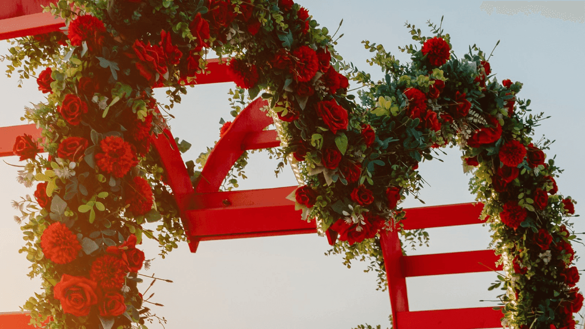 heart-shaped flower arrangement on a beach at sunset.