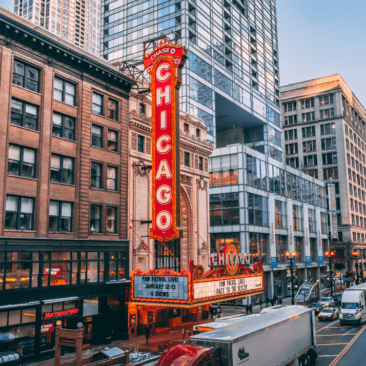 Chicago Theatre sign above the marquee by high-rise buildings and busy street traffic near the Hotel Saint Clair entrance