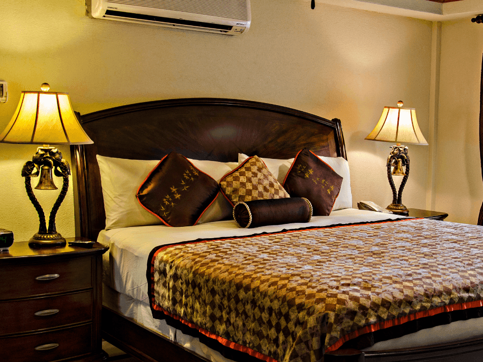 King bed with bedside lamps in Deluxe Ocean View Junior Suite at Accra Hotels