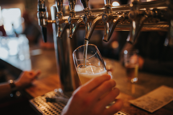 a bartender pours beer from a tap