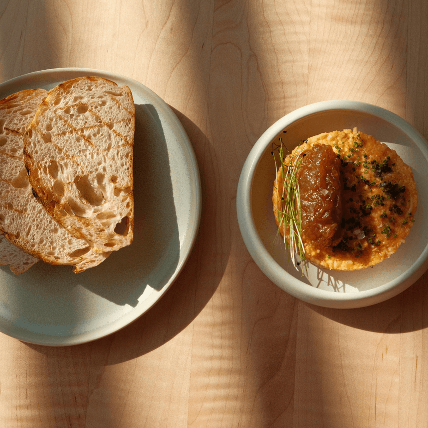 Sourdough bread alongside a plate with a spread served at The Stonebreaker Hotel