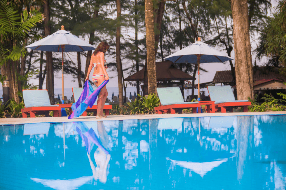 A woman walking by the pool at Amora Hotel