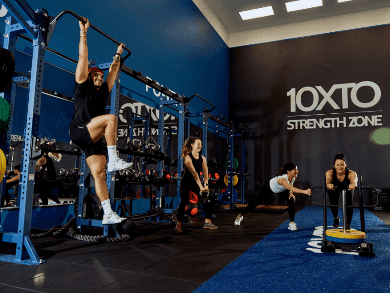 Guests exercising with pull-up bars, kettlebells and a weighted sled in the 10XTO Strength Zone at Hotel X Toronto