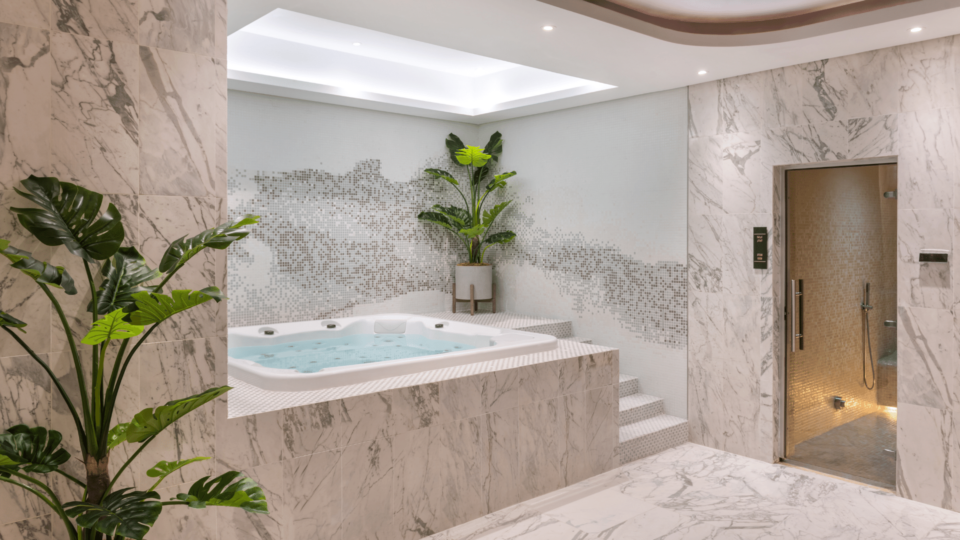 Luxurious jacuzzi room with marble accents, subtle lighting, and a tropical plant at Paramount Hotel Midtown spa