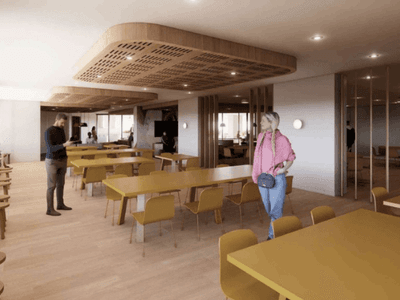 A communal area with yellow chairs and wooden tables in the UniLodge Brisbane City.
