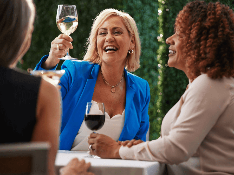 three business women enjoying wine after their meeting on the veranda at ICONA Avalon