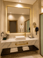 Vessel sink on countertop with folded towels under illuminated mirror in Deluxe Skyline View at Naviti by Warwick Jeddah