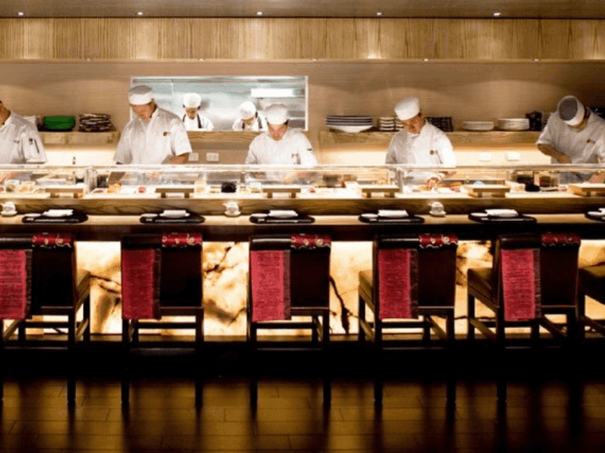 High chairs facing the open kitchen where the chefs are cooking