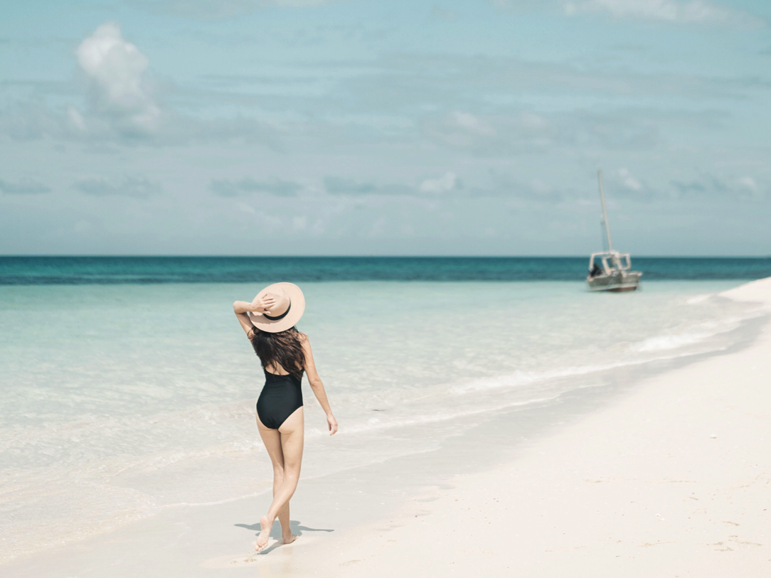 A lady on the beach with a sun hat at Haven Riviera Cancun