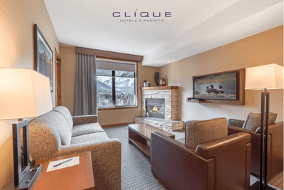 Living area of a suite at Falcon Crest Lodge features comfortable seating around a fireplace and a flat-screen television