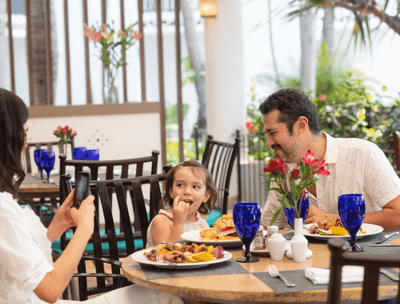 Family dining at Sunset Restaurant with women taking a photo of child at Buenaventura Grand Hotel and Spa