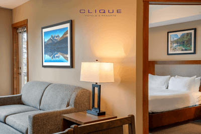 Comfortable suite at Falcon Crest Lodge features a cozy living area with a sofa and lamp, and a bedroom with a king-size bed