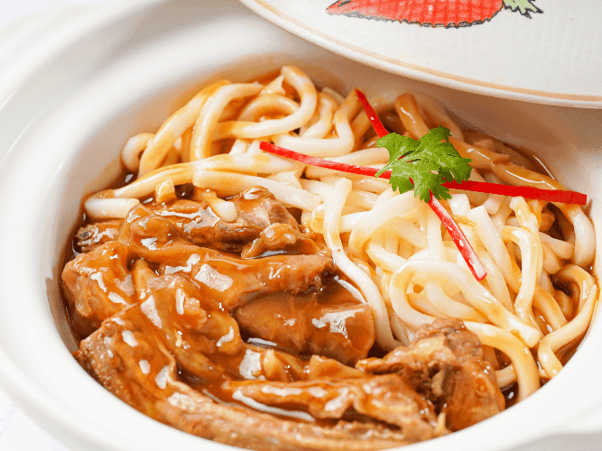 Stewed beef with udon noodles in casserole.