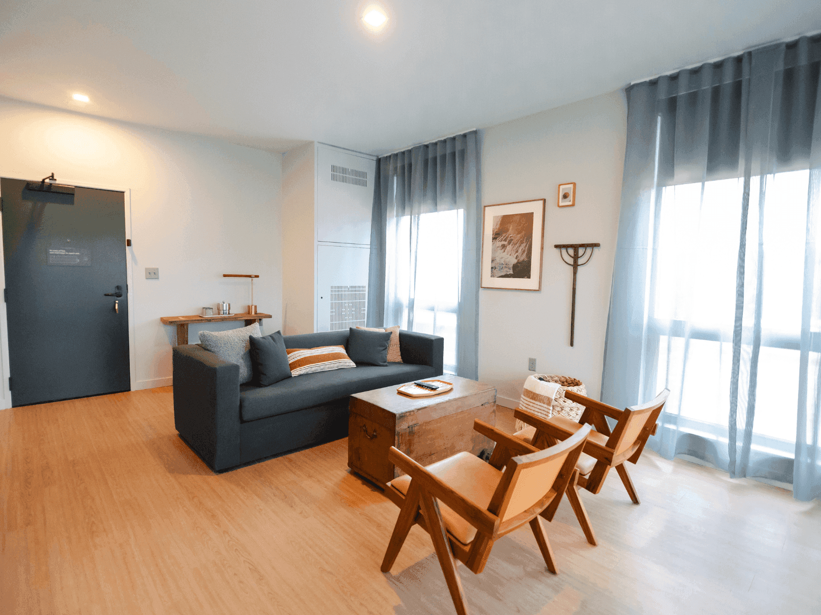 The Signature Suite at Stonebreaker showing off the living room with a pull-out couch, two chairs, and a walk out balcony.