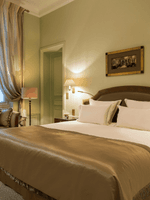 Bed with couch by the window in Deluxe Suite Parisienne at Hotel Westminster Paris