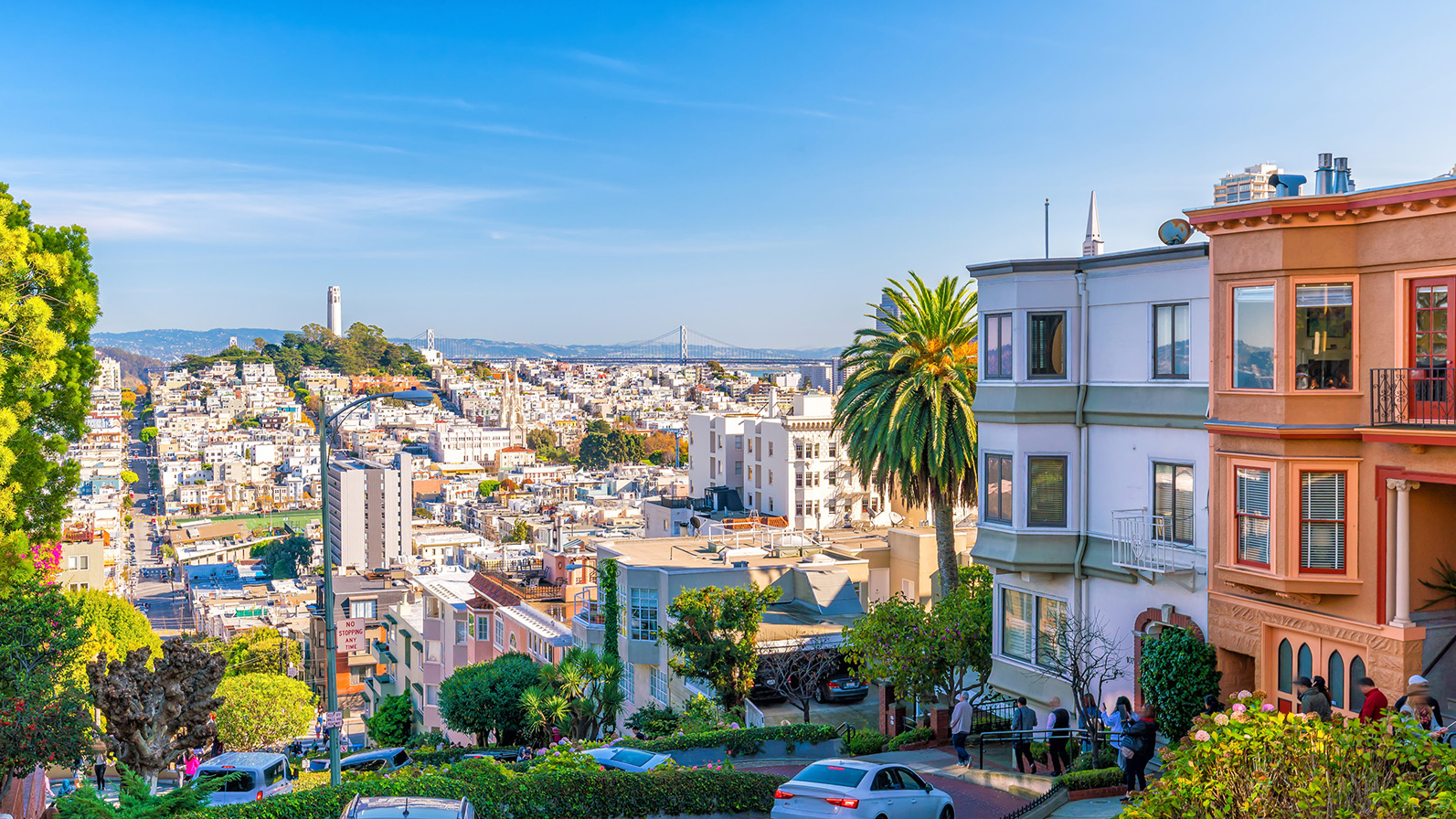 A view of San Francisco featuring Coit Tower, the Bay Bridge, and colorful buildings near Warwick Hotels and Resorts