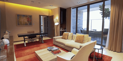 Livingroom area of Jasmine Villa with cozy sofa, abstract art, and work desk at One Farrer Hotel