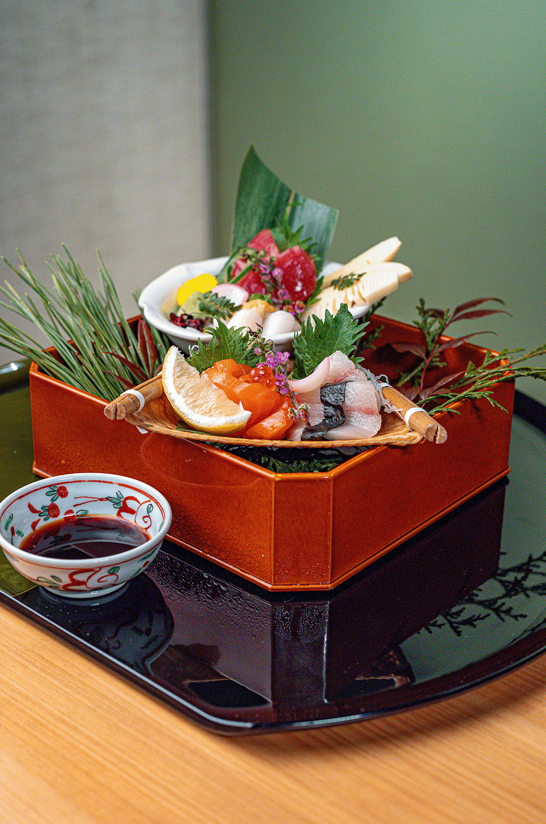 An overhead view of a traditional Japanese lacquered bowl containing fresh chirashi sushi at Hotel Okura Manila