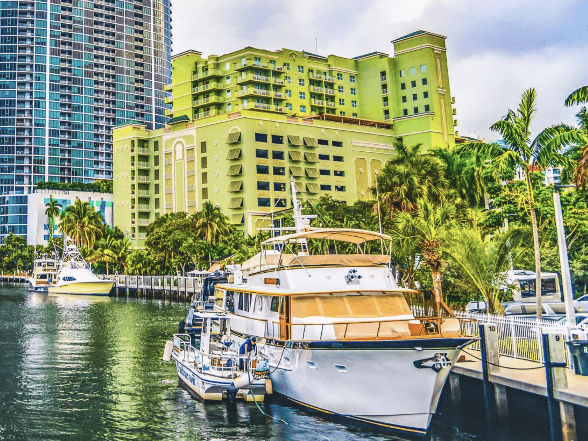 Yacht docked in a marina with Riverside Hotel Fort Lauderdale and palm trees in the background