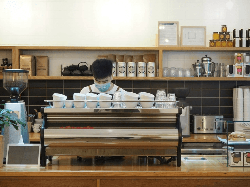 Coffee machine with a barista standing behind