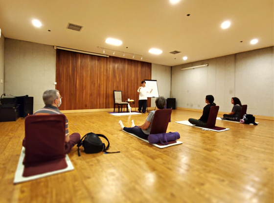 People in an indoor wellness session at Honor’s Haven