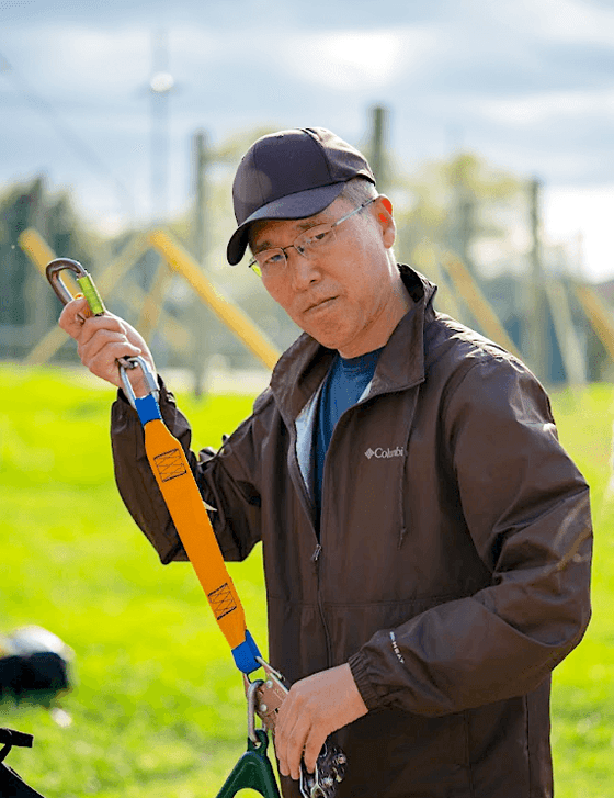 Portrait of Steve Kim holding a zipline hook at Honor's Haven Retreat