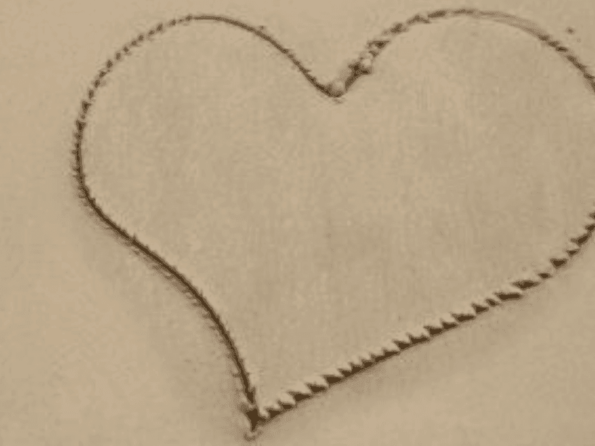 A heart drawn in the sand near The Breakwater Inn & Spa