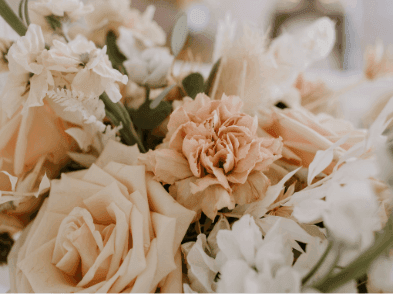 Close-up of a floral arrangement featuring soft peach roses and white flowers at Warwick Le Crystal