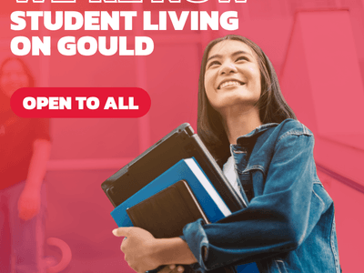 Smiling student holding books with text we're now student living on Gould open to all.