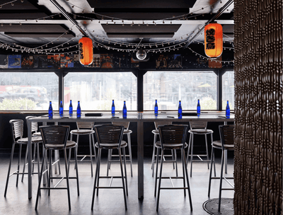 Interior of a spacious bar with tables and chairs at The Verb Hotel