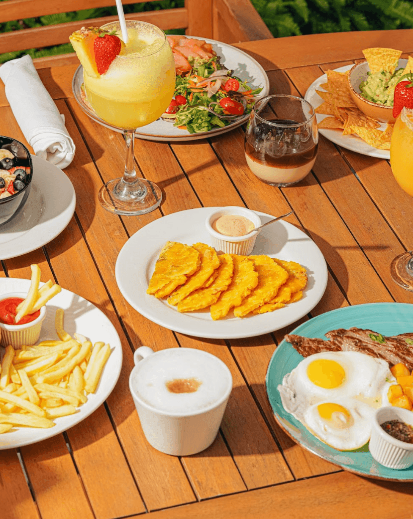 a table with various plates of food and drinks