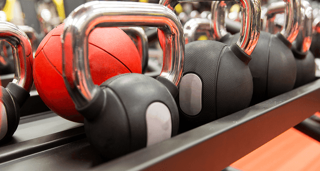 Red and black kettlebells lined up on a rack at Hotel Hacienda del Mar los Cabos