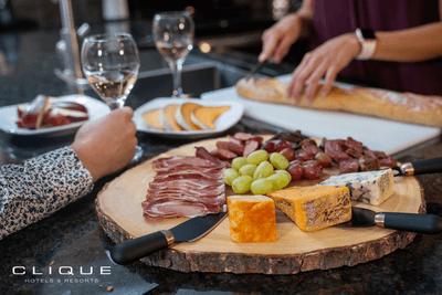 Charcuterie board with cheeses, meats, and grapes with wine glasses at Falcon Crest Lodge