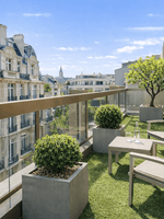 Grey lounge chairs by a small table on a grass terrace in Executive Suite with Terrace at Warwick Paris Champs Elysées