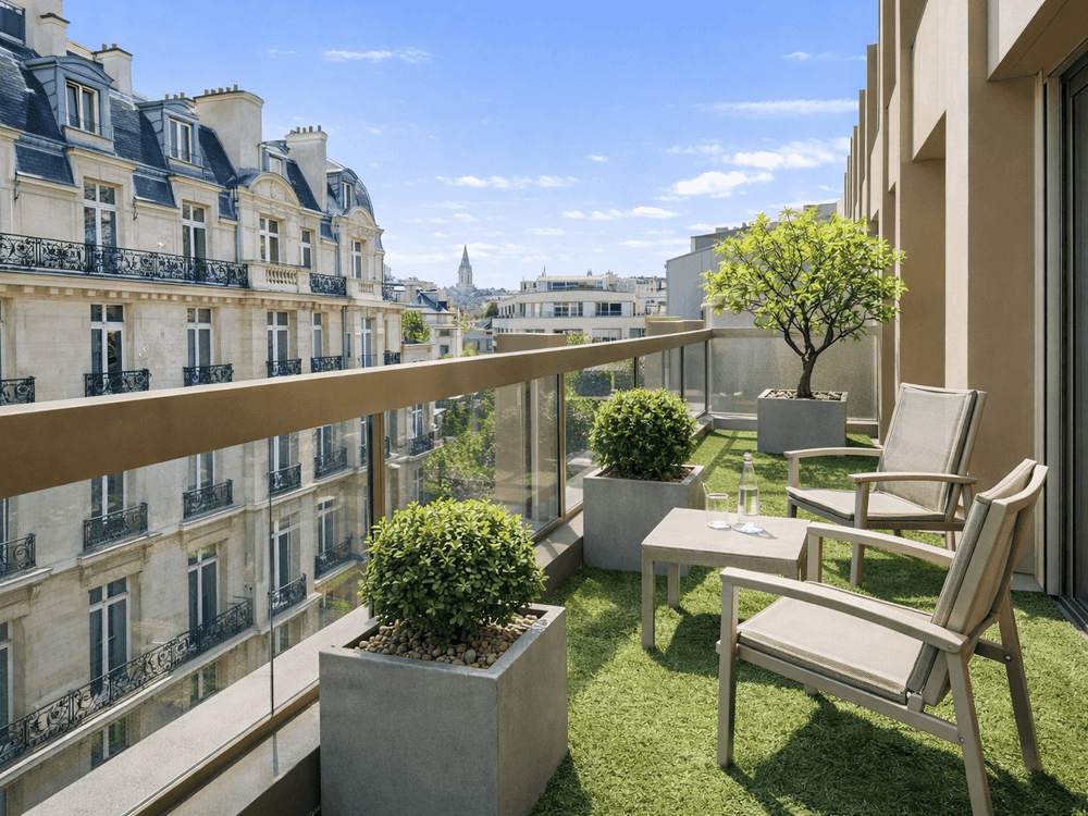 Grey lounge chairs by a small table on a grass terrace in Executive Suite with Terrace at Warwick Paris Champs Elysées