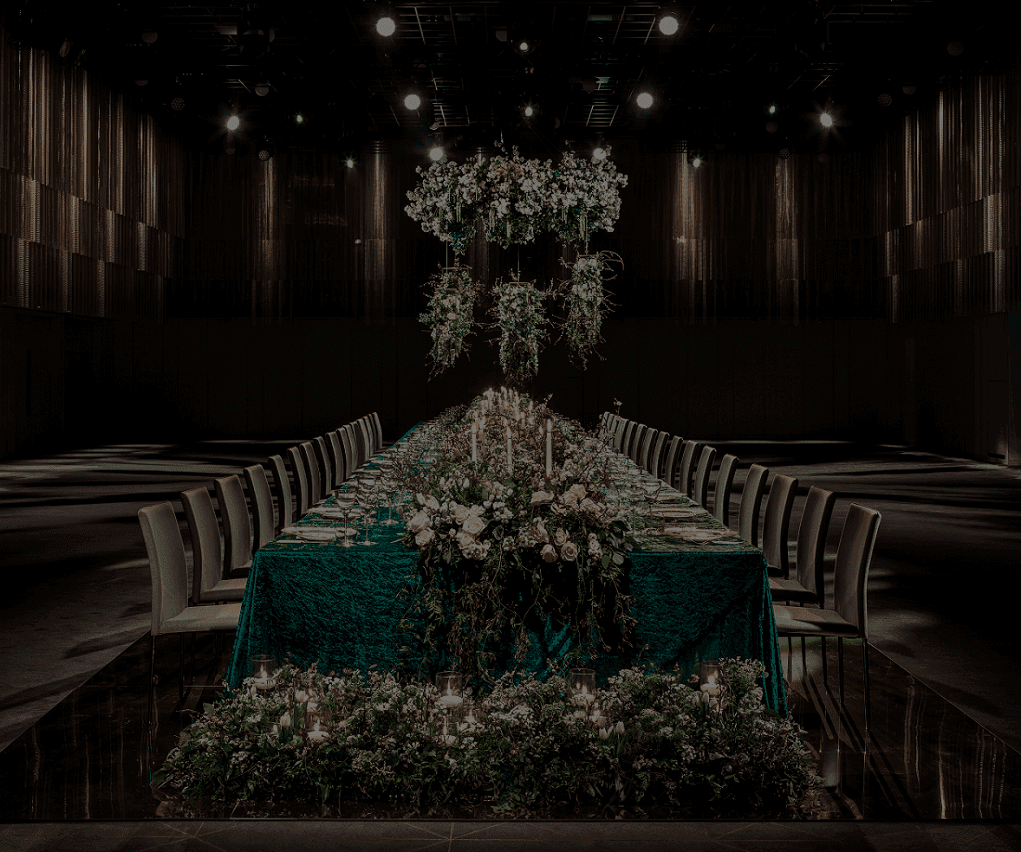Large dining table featuring neatly placed chairs floral arrangements and elegant lighting at The Londoner Hotel