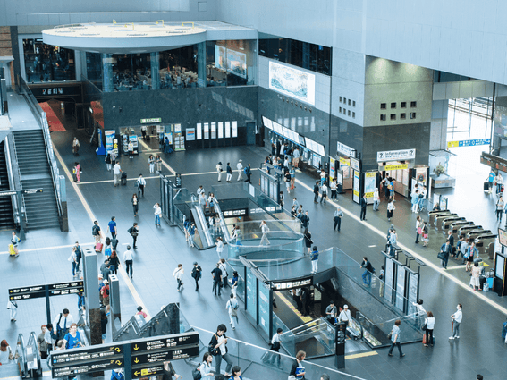 Busy Kyoto Station interior with passengers and information boards near Park Hotel Kyoto