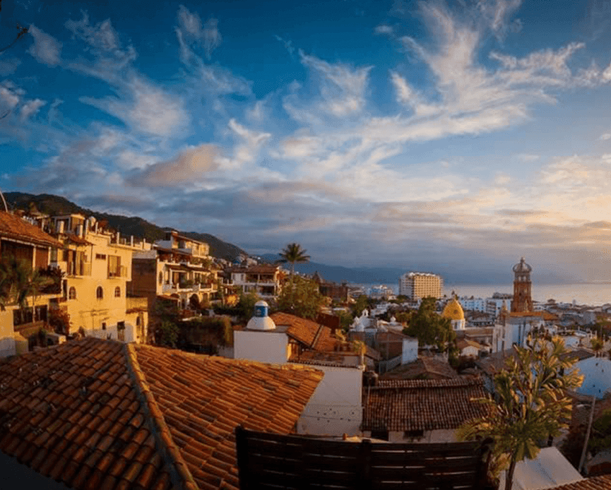 High-angle view of terracotta tiled roofs overlooking the historic city skyline from Casa Dona Susana