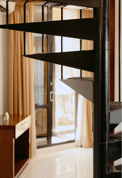 Modern interior featuring a sleek black spiral staircase in the foreground at Amora Herencia Riverwalk Melbourne