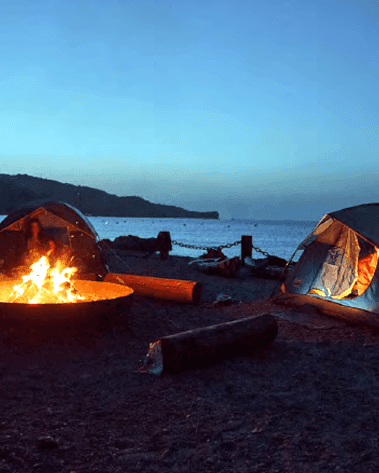 Tents set-up by a campfire overlooking the sea near Catalina Island Company