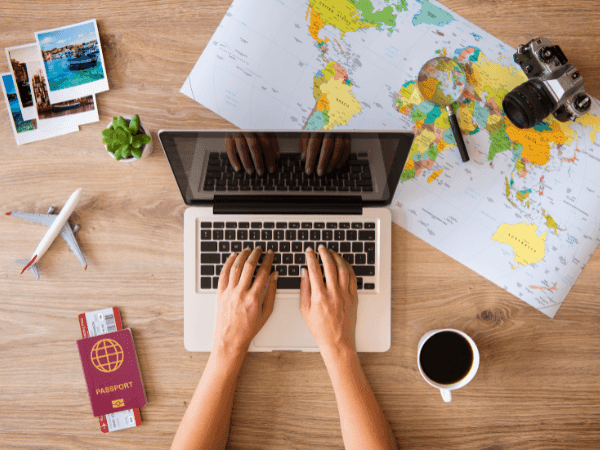 Person working on the laptop with a map, camera, passport and coffee at Polonia Palace Hotel