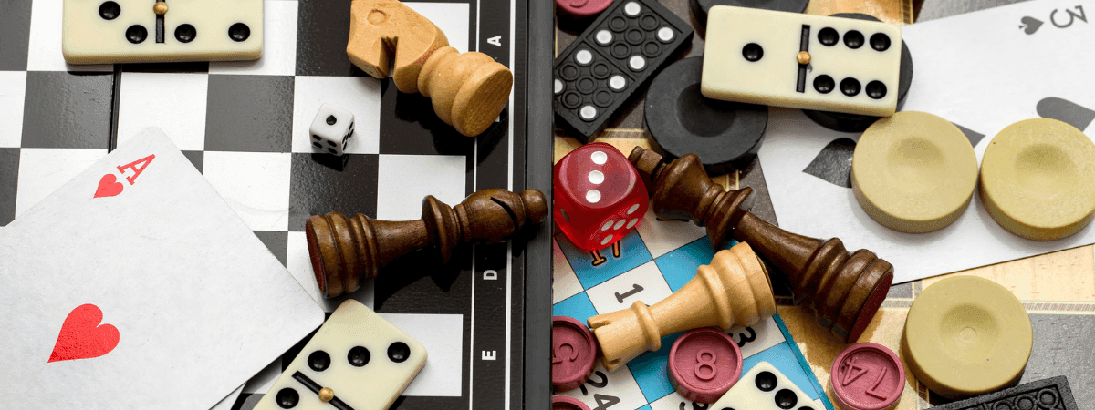 Game pieces, cards, and dominoes are scattered on a game board at Warwick Hotels and Resorts