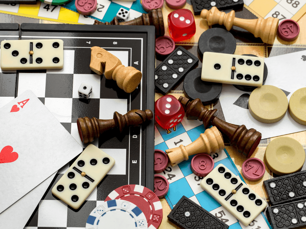 Game pieces, cards, and dominoes are scattered on a game board at Warwick Hotels and Resorts