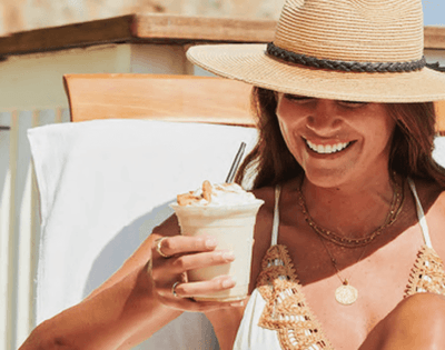 Lady enjoying a milkshake while lounging on a sunbed near Catalina Island Company